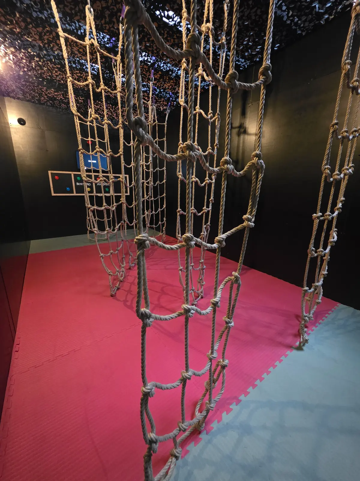 Des filets de corde suspendus au-dessus d'un tapis rouge, un défi d'agilité de Défis Pirate Perpignan