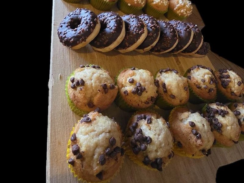 Muffins aux pépites de chocolat et donuts sur une planche en bois