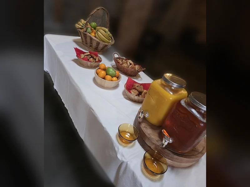 La table du petit déjeuner : viennoiseries, corbeille de fruits et fontaines de jus