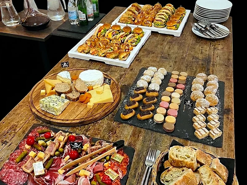 Un buffet sur table en bois : plateaux salés, fromages, charcuterie et douceurs