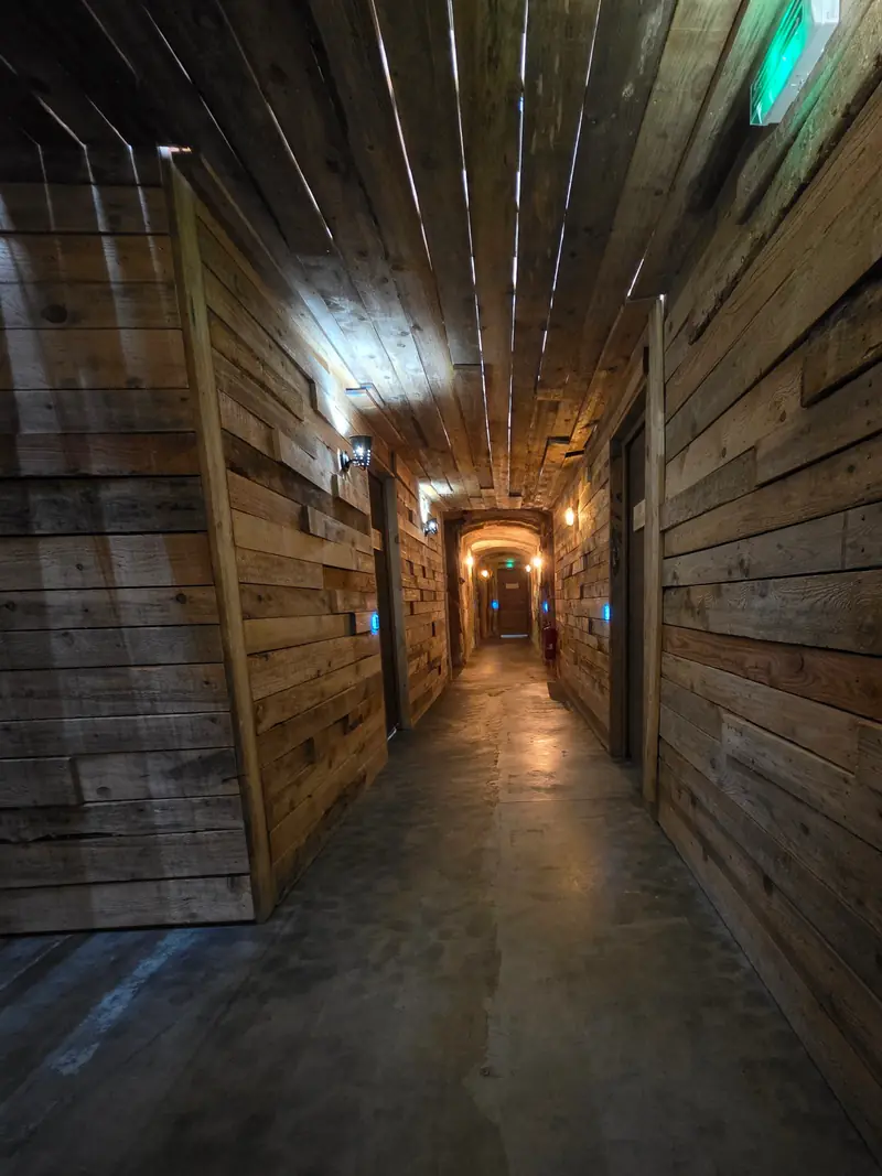 Un long couloir de planches de bois, comme dans la cale d'un navire