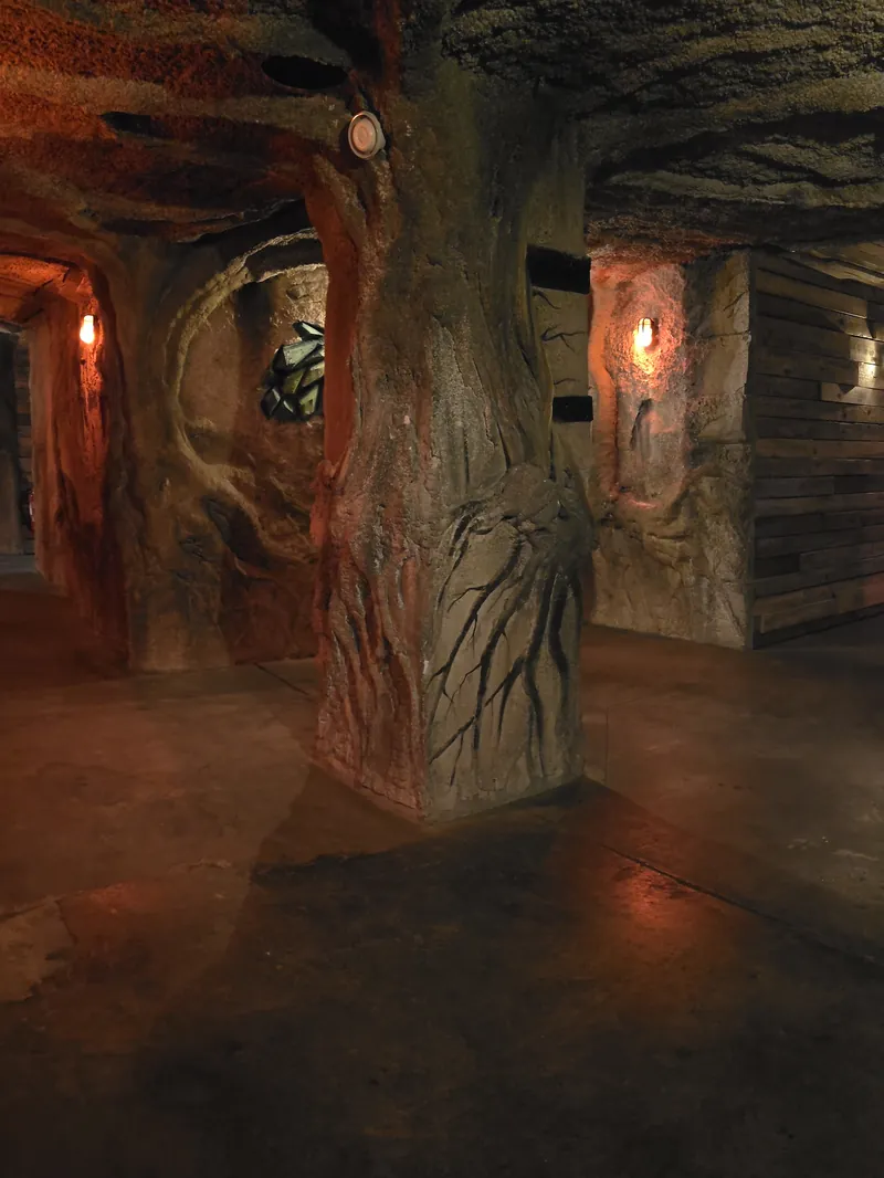 Une galerie creusée dans la roche, éclairée de torches