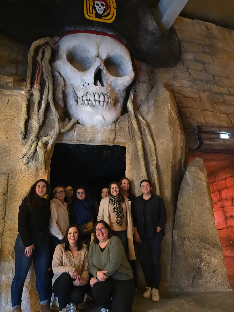 Une équipe pose sous le crâne géant de Défis Pirate Perpignan, à la fin de sa mission