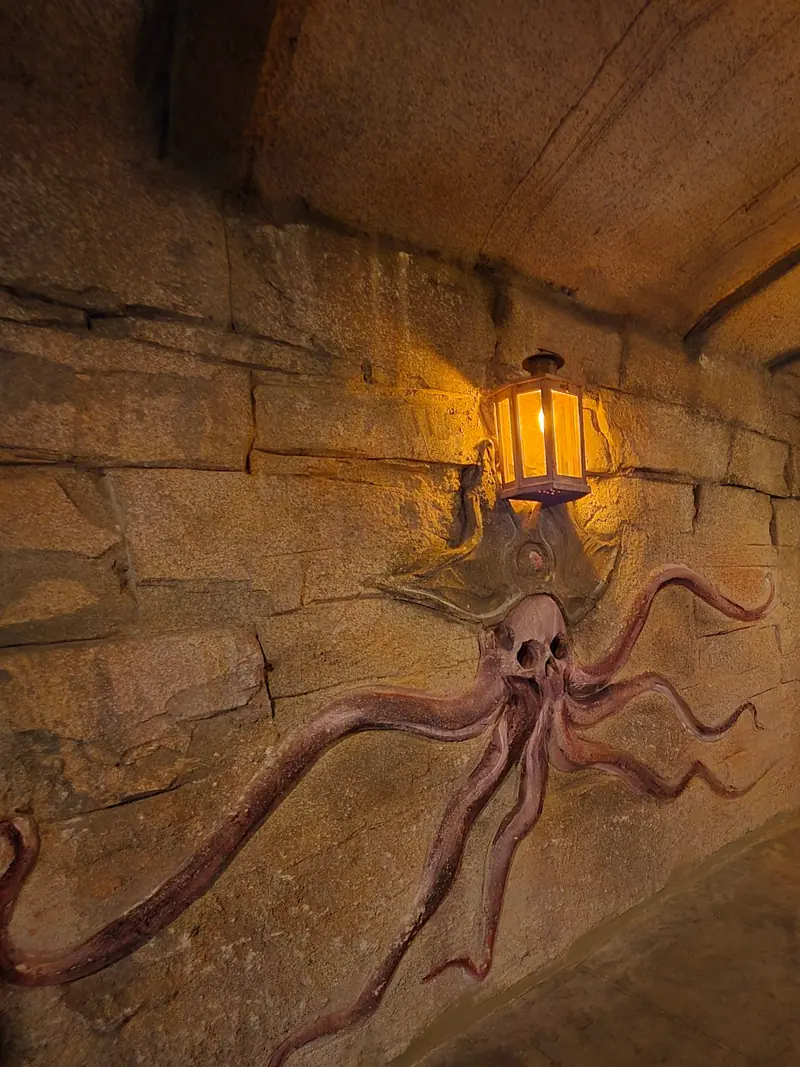 Une pieuvre à tête de crâne sculptée dans la pierre, sous une lanterne