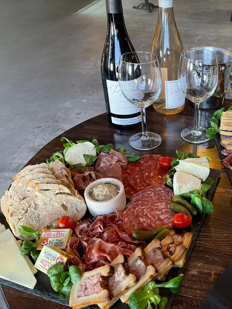 Une planche apéritive de charcuterie et de fromages, servie avec du vin
